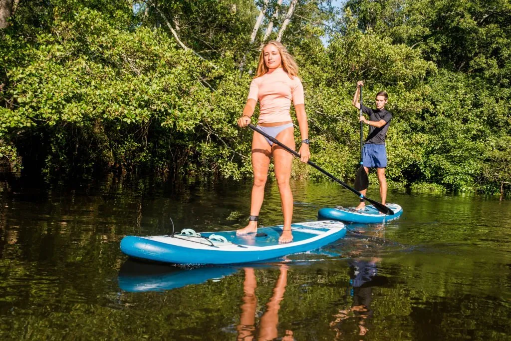 Pareja haciendo paddle surf en aguas tranquilas